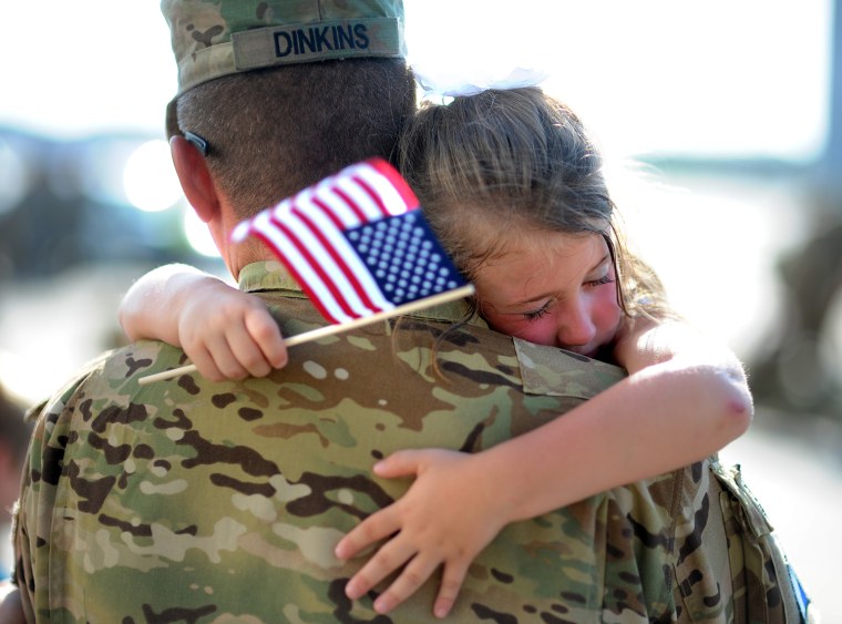 Image: U.S. Army Staff Sgt. Jason Dinkins with the 3rd Combat Aviation Brigade is hugged by his daughter.